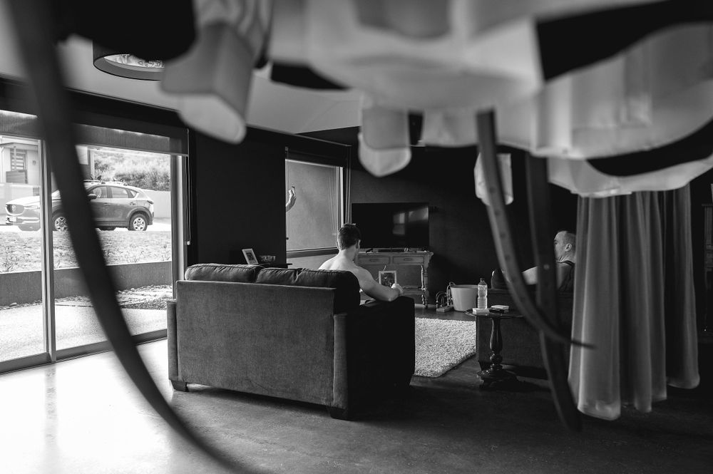 Black and white interior room with furniture and hanging clothes in soft lighting.