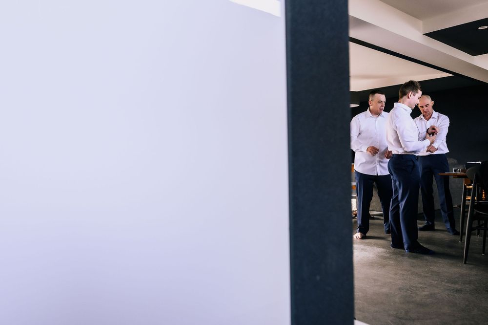 People in white shirts standing near a wall in modern office space.