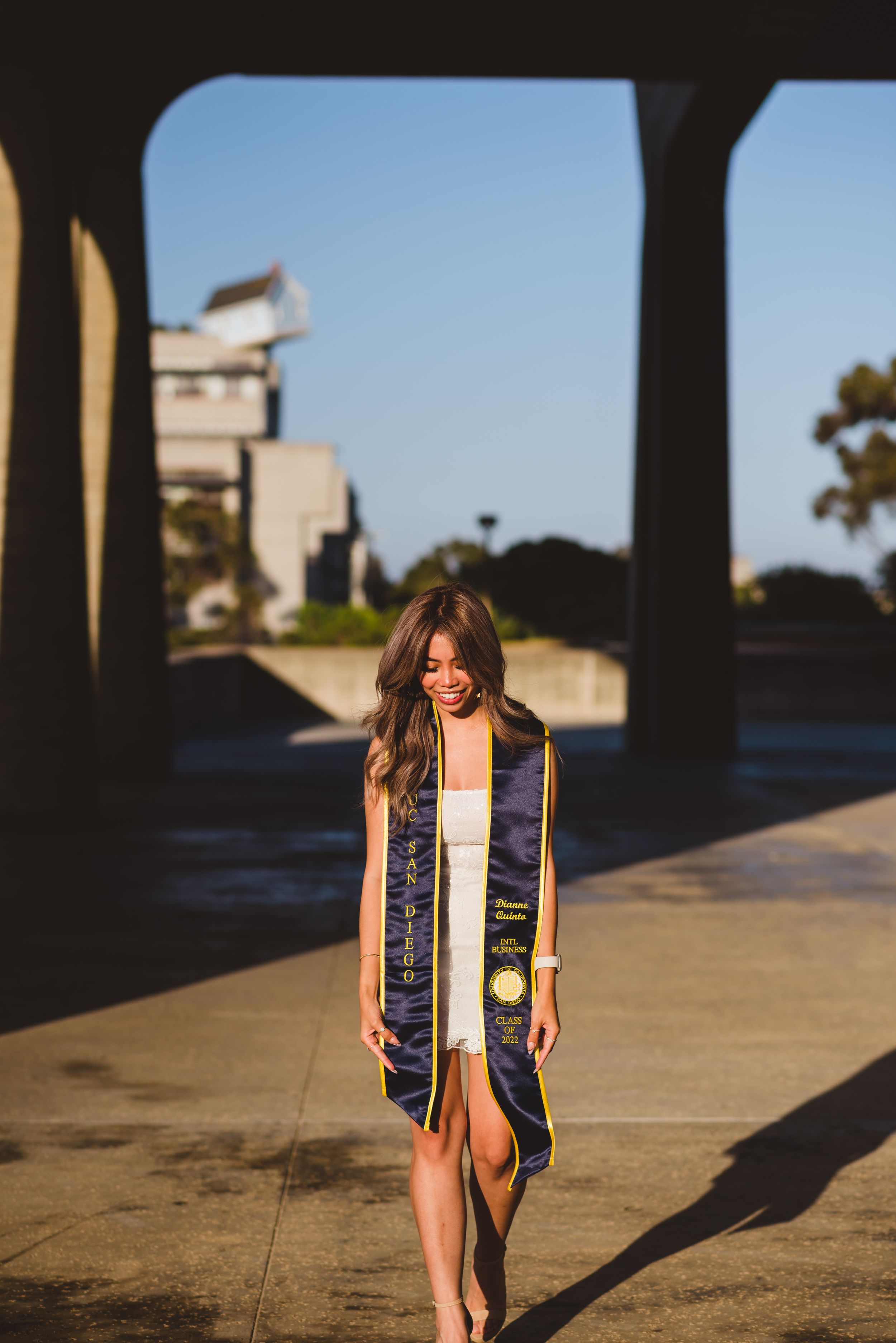 UC San Diego graduate posing for a photo looking down.