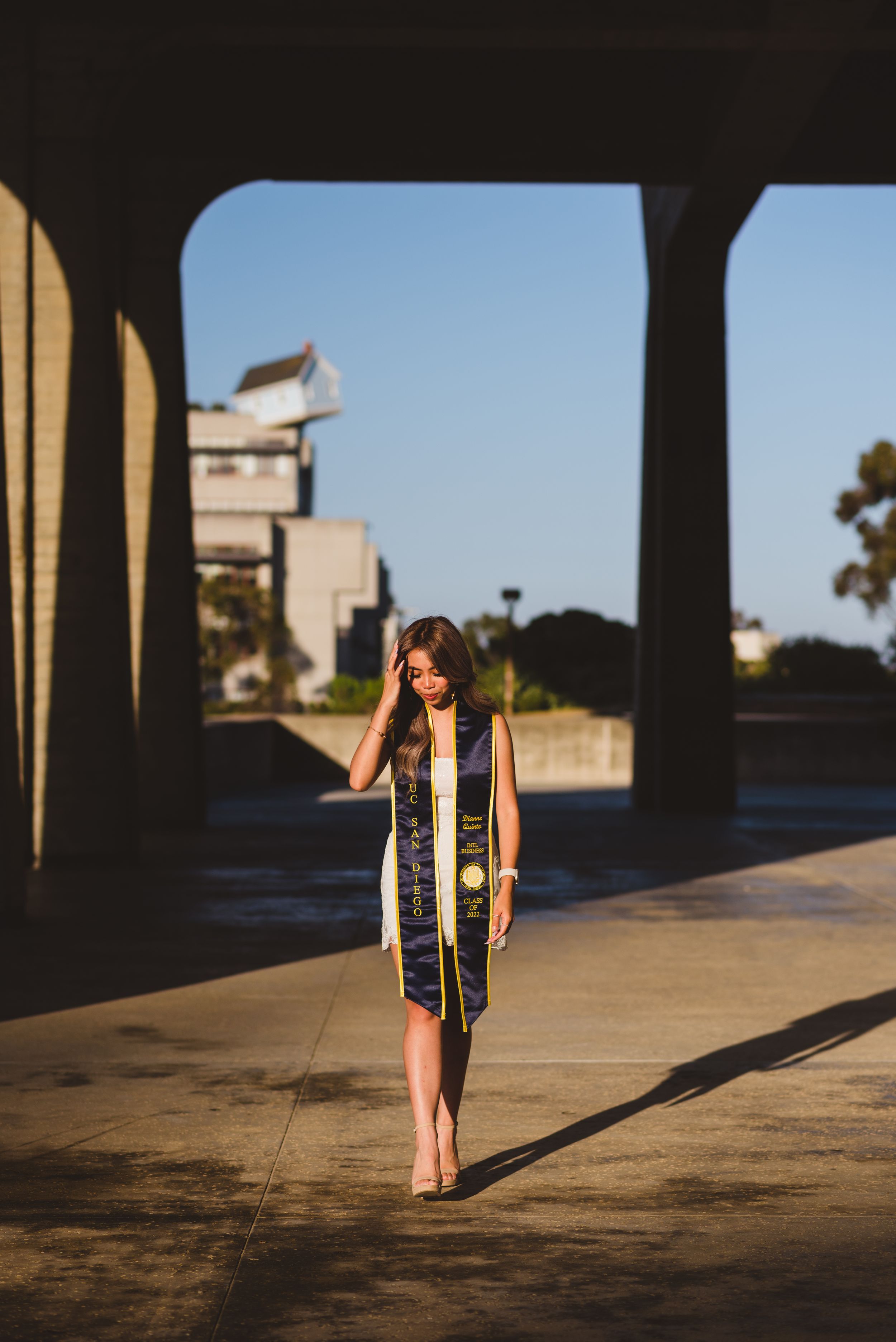 UC San Diego graduate posing for a photo looking down.