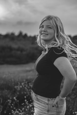 A series of black and white portraits showing someone with blonde hair in denim against a rural landscape.