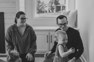 Family members gathered in a living room sharing conversation and laughter together during a casual get-together.