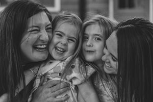 A series of black and white photos showing joyful people embracing and laughing together.
