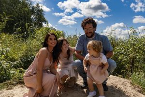 Family enjoying a sunny summer day together in a wildflower meadow.