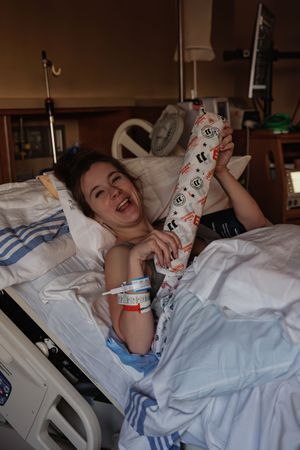 Patient resting in hospital bed with a Jimmy Johns sub shows joyful expressions after her babies arrival.