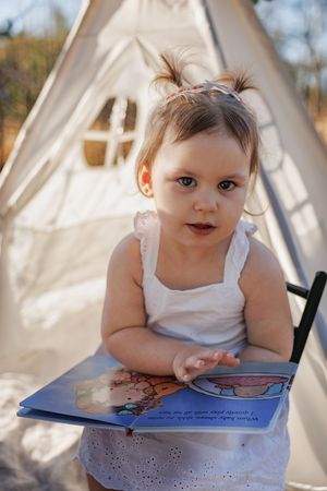 Big sister reading about becoming a big sister at a family maternity photo session