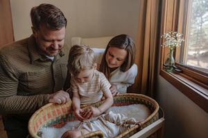 Family enjoying creative activity together by window in cozy home setting.