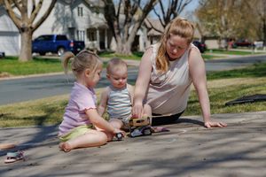 Chalk in the driveway while dad does lawncare before baby brother arrives, lifestyle maternity photo session at home