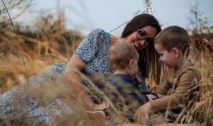 A peaceful moment shared in a golden wheat field during sunset as they huddle together in warm natural lighting.