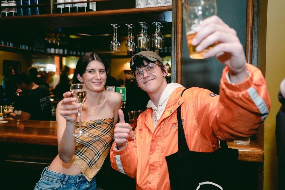 Friends raising drinks for a toast at a bar counter.