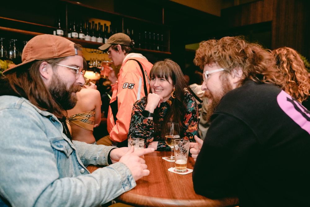 Friends enjoying drinks and conversation at a cozy bar.