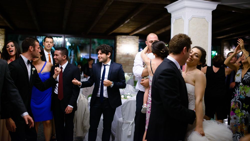 Wedding reception dance floor with guests celebrating in an indoor venue.
