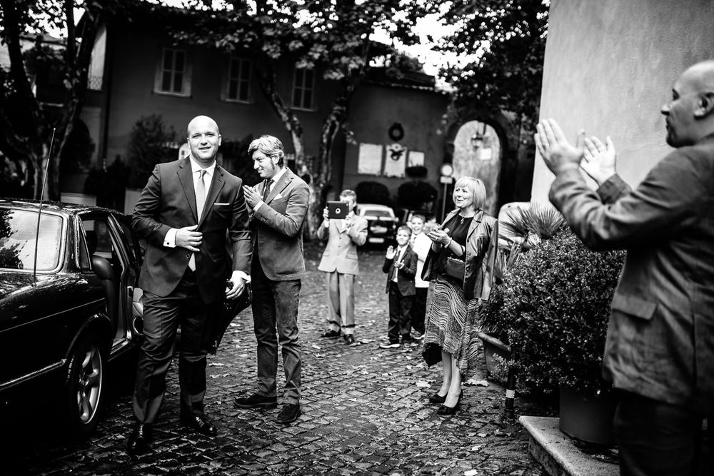 Black and white candid shots of wedding guests enjoying outdoor festivities.
