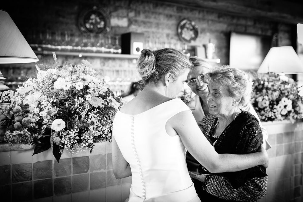 Black and white wedding reception scene with elegant table settings and floral arrangements.