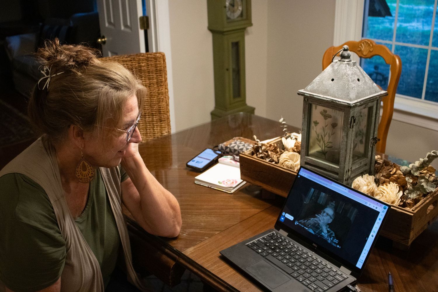 A lady watching a video on a laptop on a table