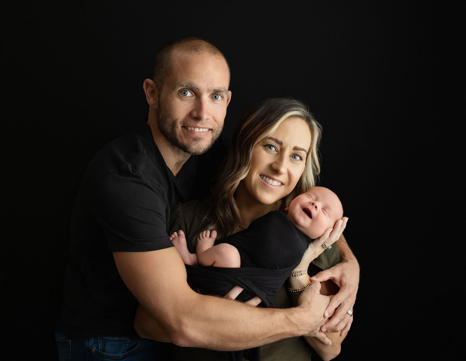 Mother and father holding their newborn baby.