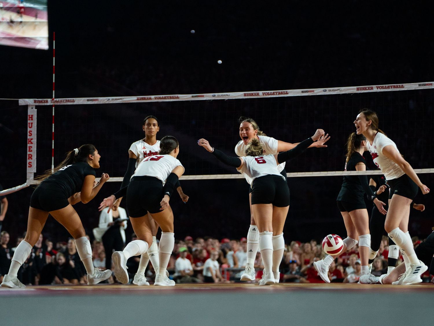Photo of volleyball players in action during a competitive match.