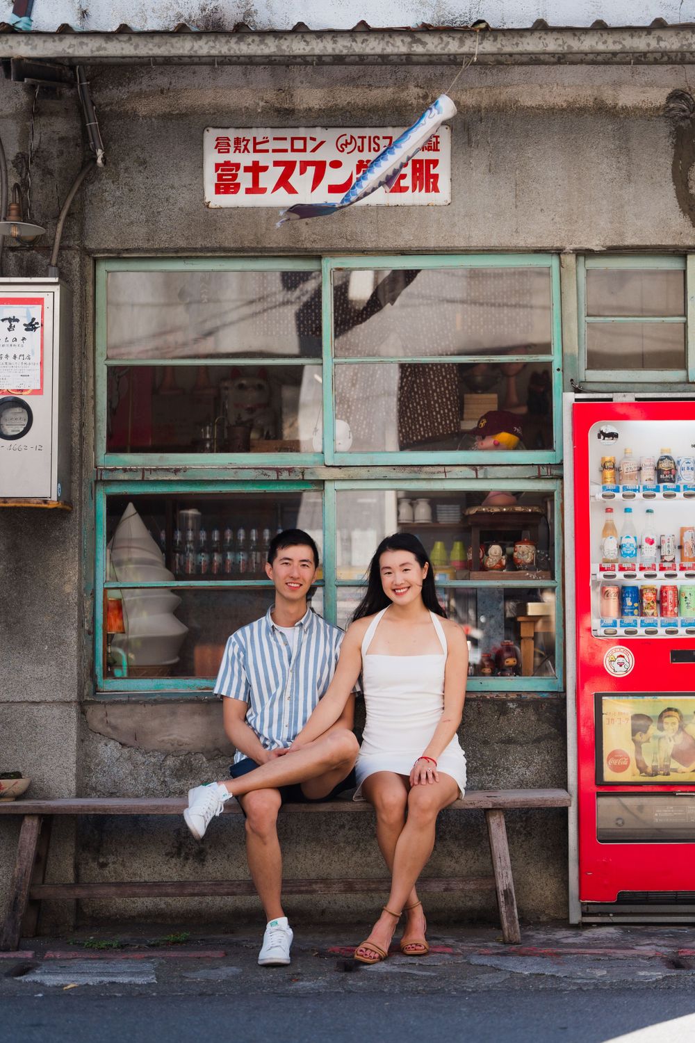 A couple sitting in front of a vintage grocery store at Dihua Street in Dadaocheng District.