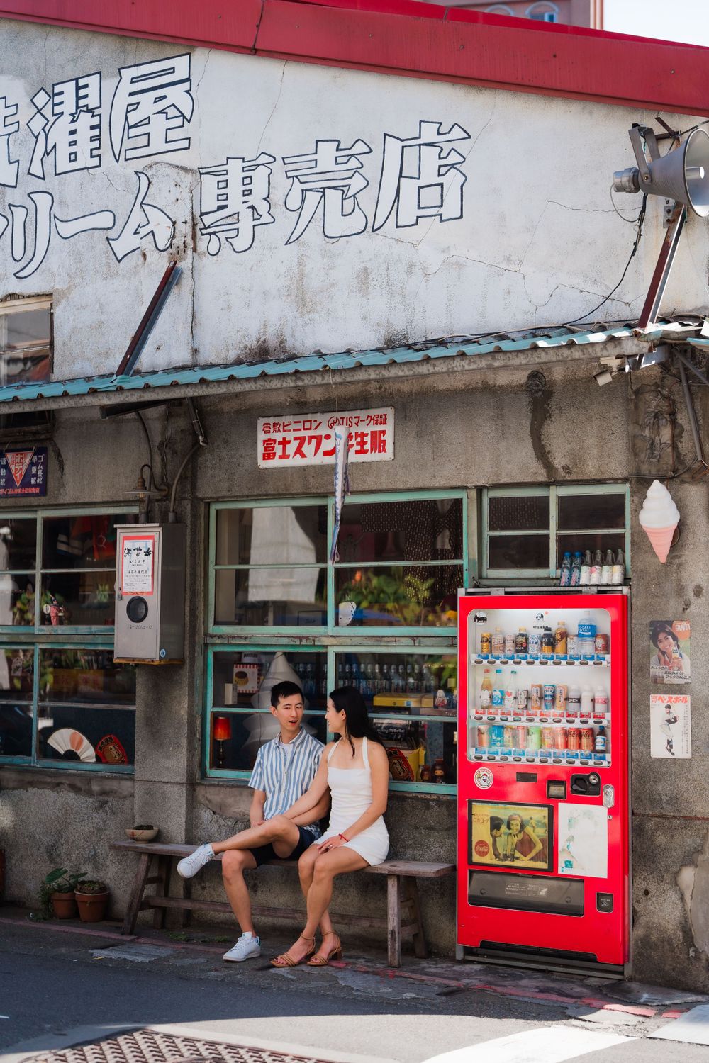 A couple sitting in front of a vintage grocery store at Dihua Street in Dadaocheng District.
