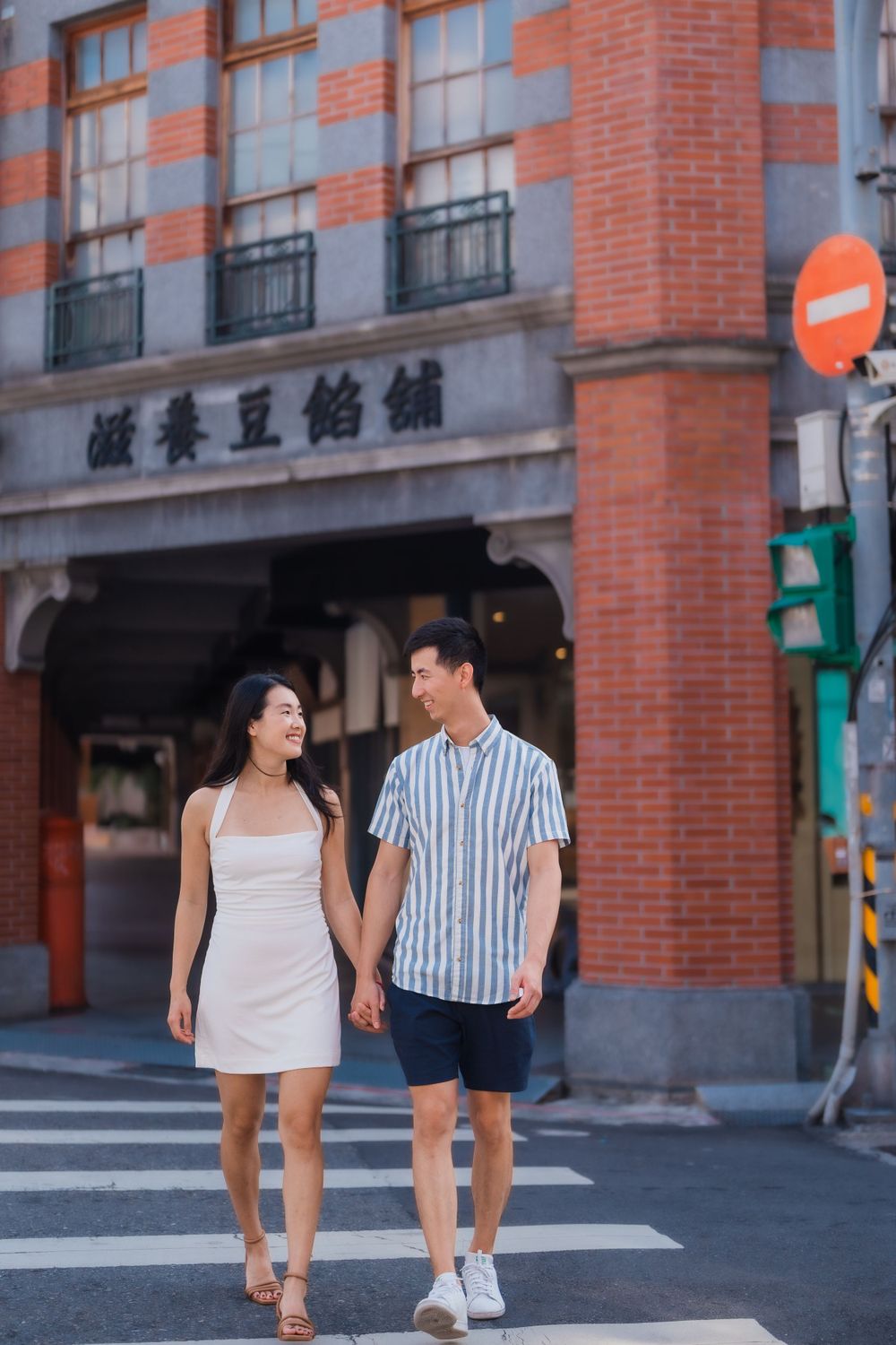 A couple crossing the streets of Dihua Street at Dadaocheng in Taipei City.