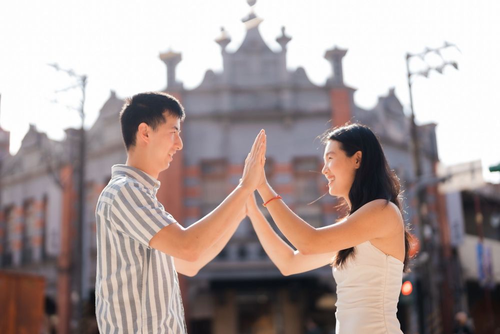 A couple doing high five at Dihua Street in Dadaocheng in Taipei City.