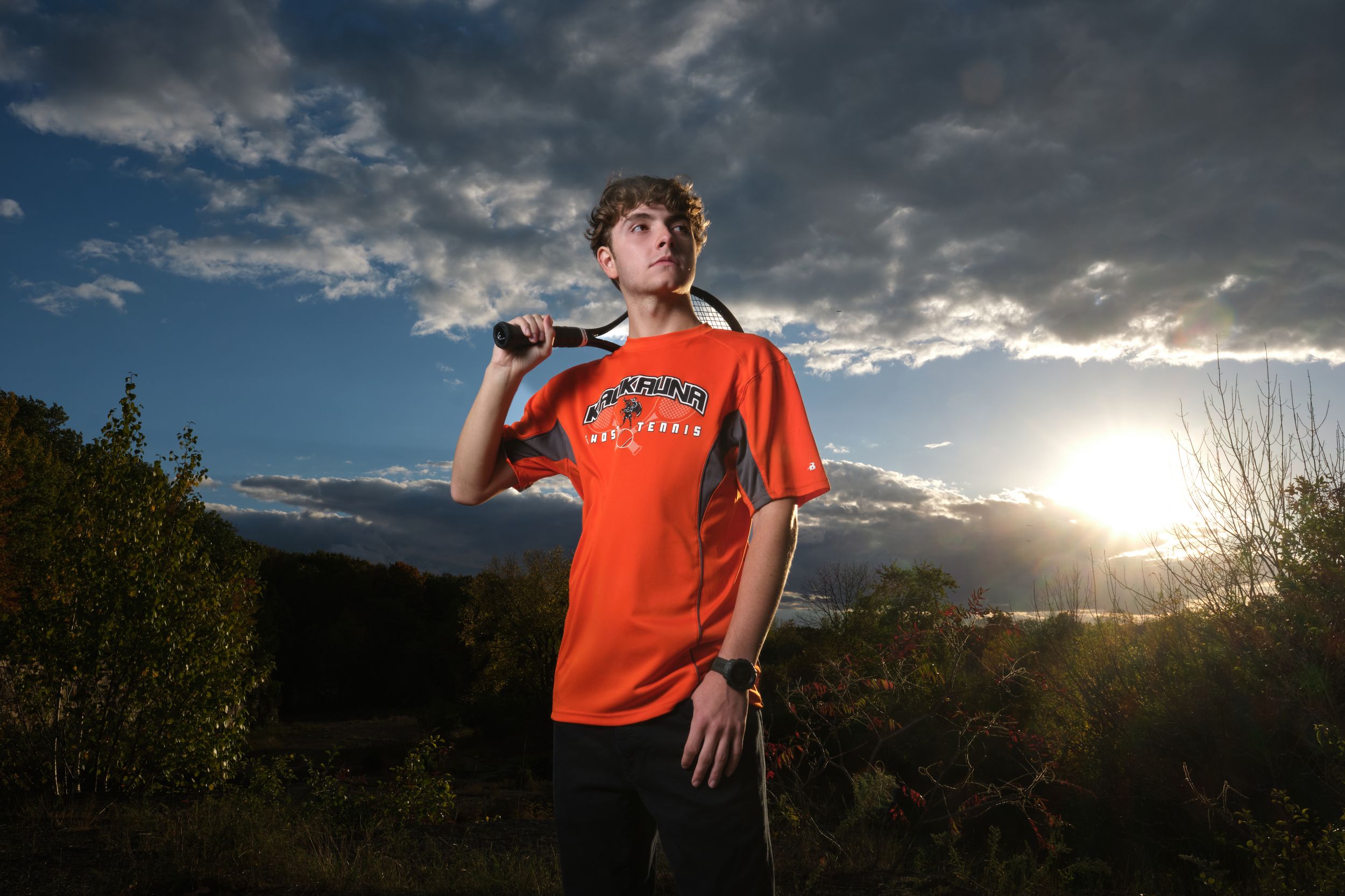 a senior portrait of a tennis player during the sunset