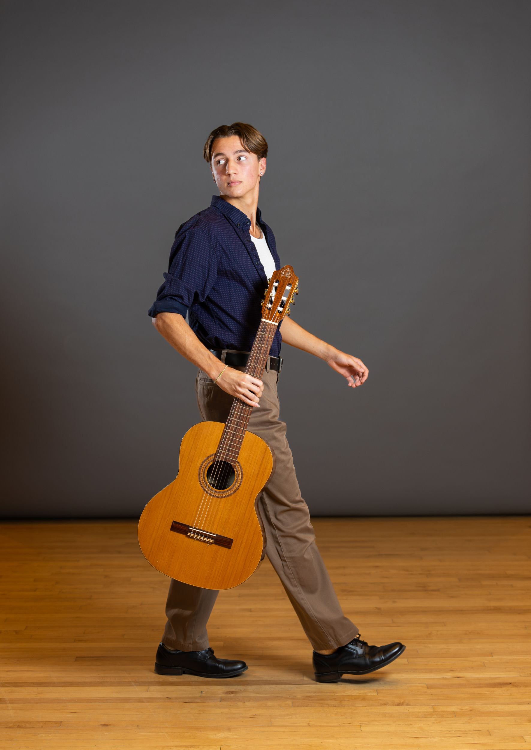 A guitar player poses for a studio portrait