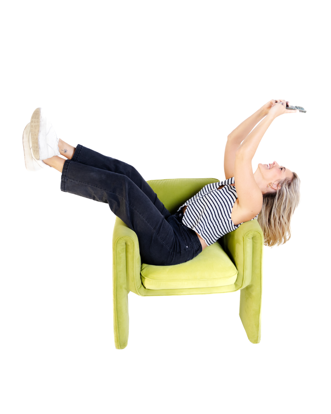 Playful blonde woman taking a selfie while lounging in a lime green modern accent chair.