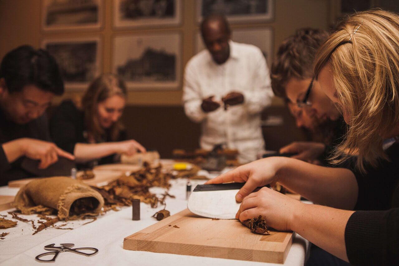 Group workshop participants working together on crafts at a table with various materials.