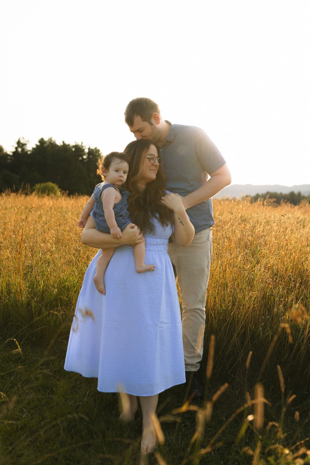 A couple with a baby share tender moments in a golden wheat field at sunset, creating a series of heartwarming silhouettes.