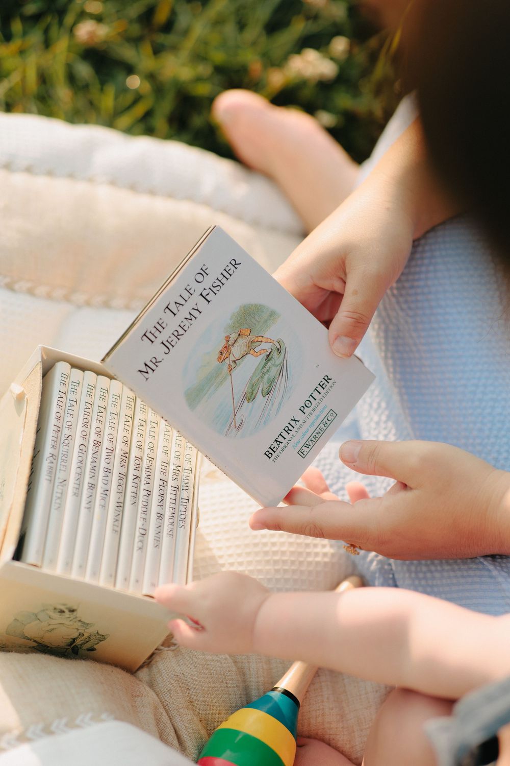 Someone's hands flip through crisp pages of white hardcover books against a light-colored textured background.