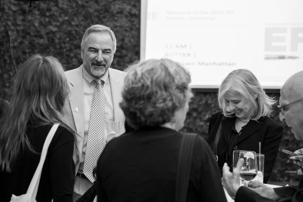 Black and white photograph of business professionals networking at a formal event.