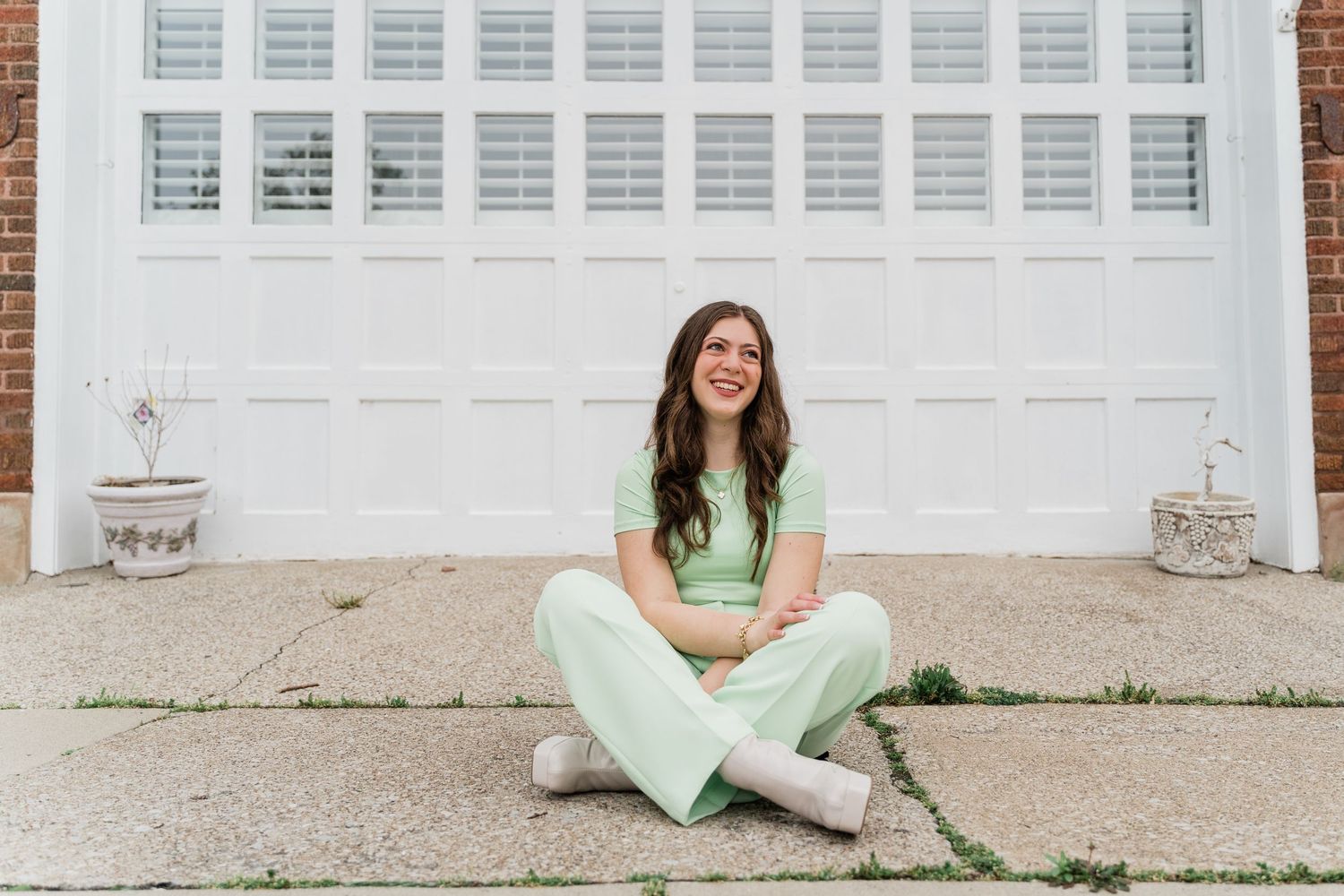 Perrysburg High School senior posing against a white garage door and brick wall background in Downtown Perrysburg photo session.
