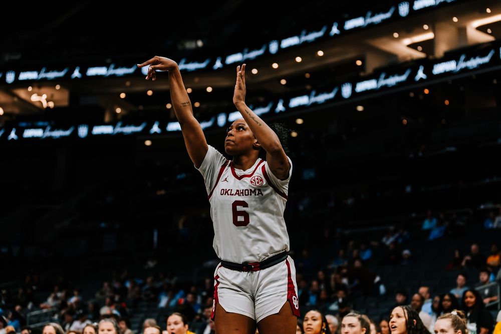 Oklahoma women's basketball player #6 celebrates while gesturing to the crowd during a game.