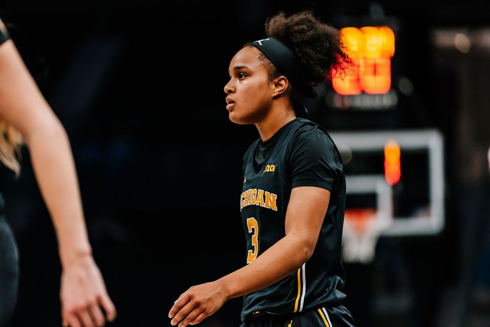 Michigan women's basketball player #3 stands on the court during a college basketball game.