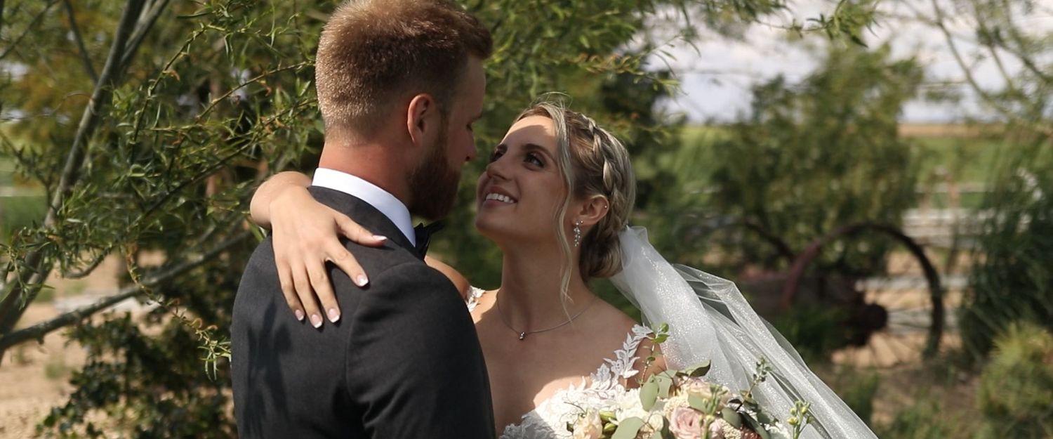 Romantic wedding couple embracing in a lush garden setting during golden hour.