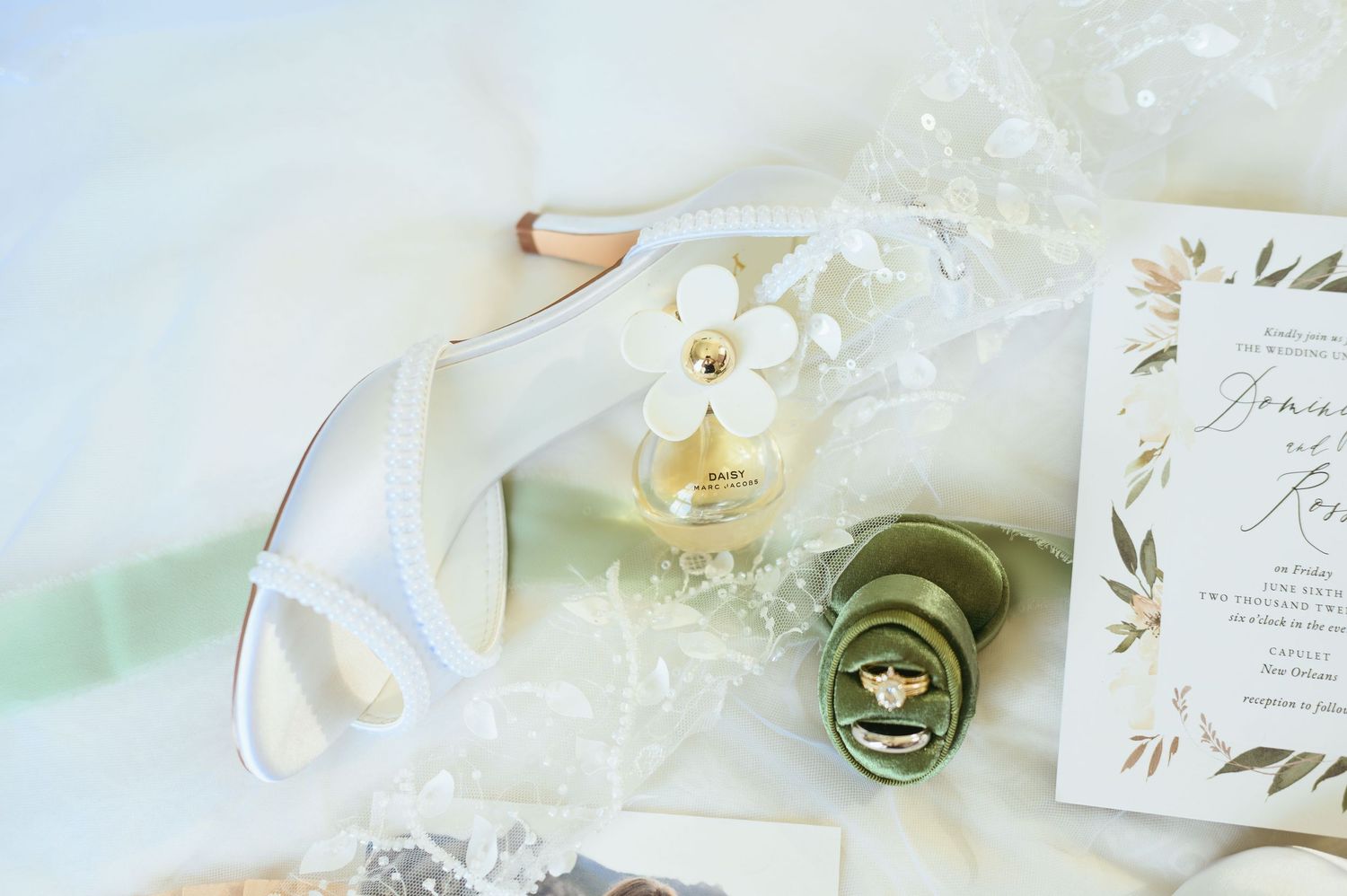 Wedding stationery and decorative details arranged in soft white tones.