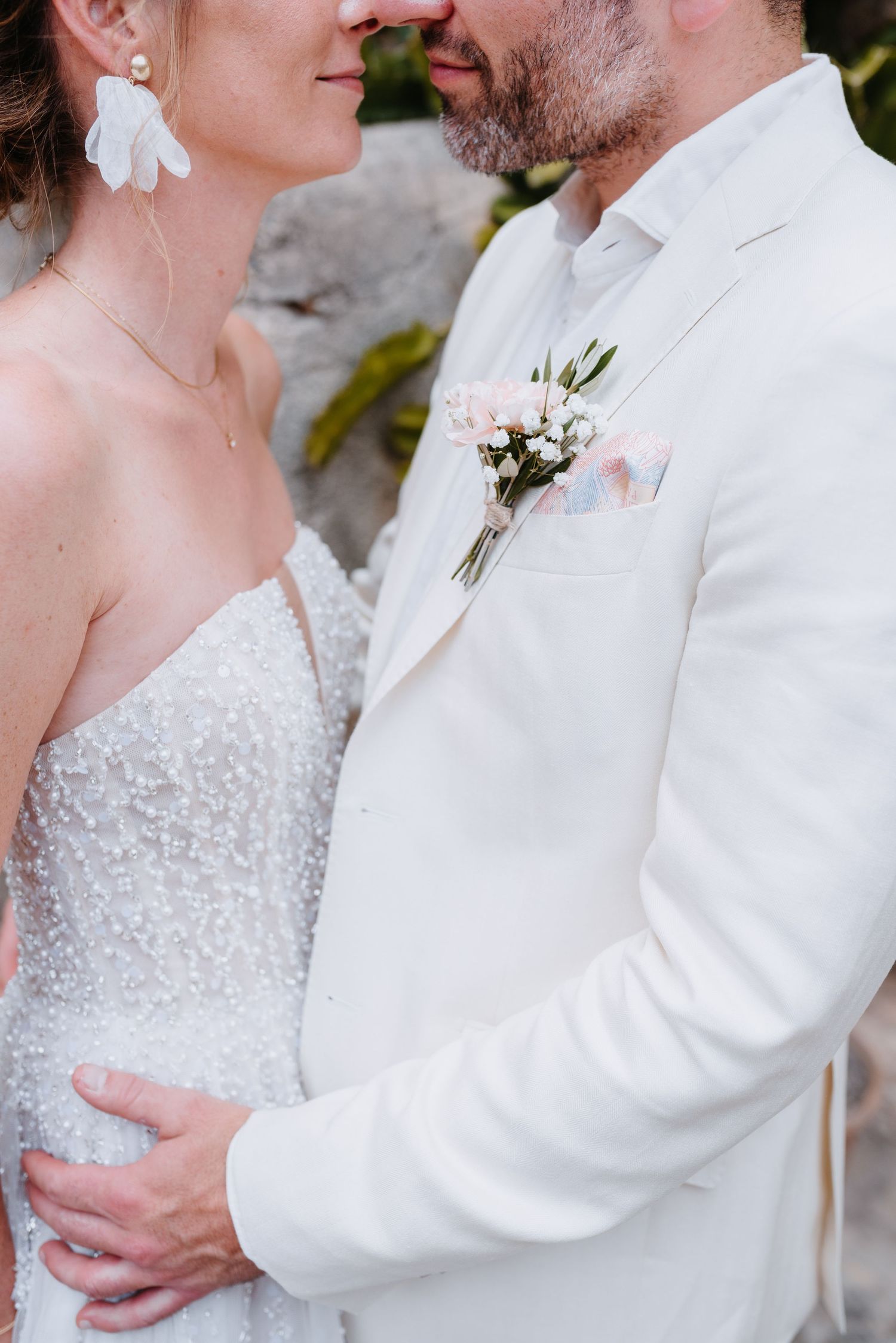 Close-up eines frisch verheirateten Paares in weißer Hochzeitskleidung, das sich in einem zärtlichen Moment umarmt. Mallorca Hochzeit Finca.