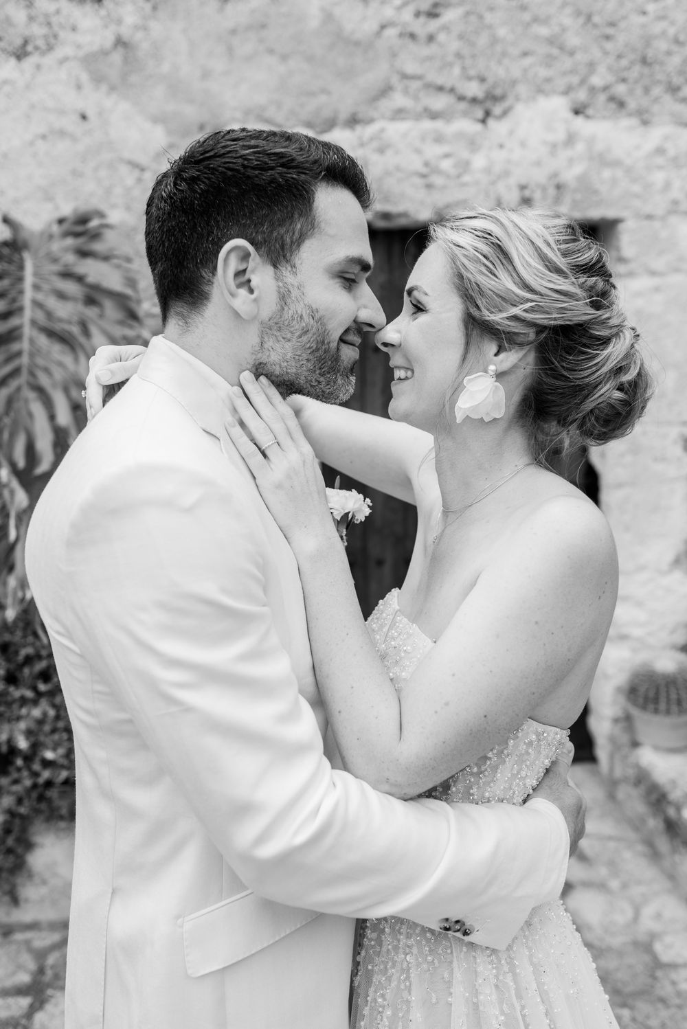 Eine romantische Hochzeitsfotografie, die einen intimen Moment zwischen dem Brautpaar in Schwarz-Weiß, während ihres First Looks, zeigt.