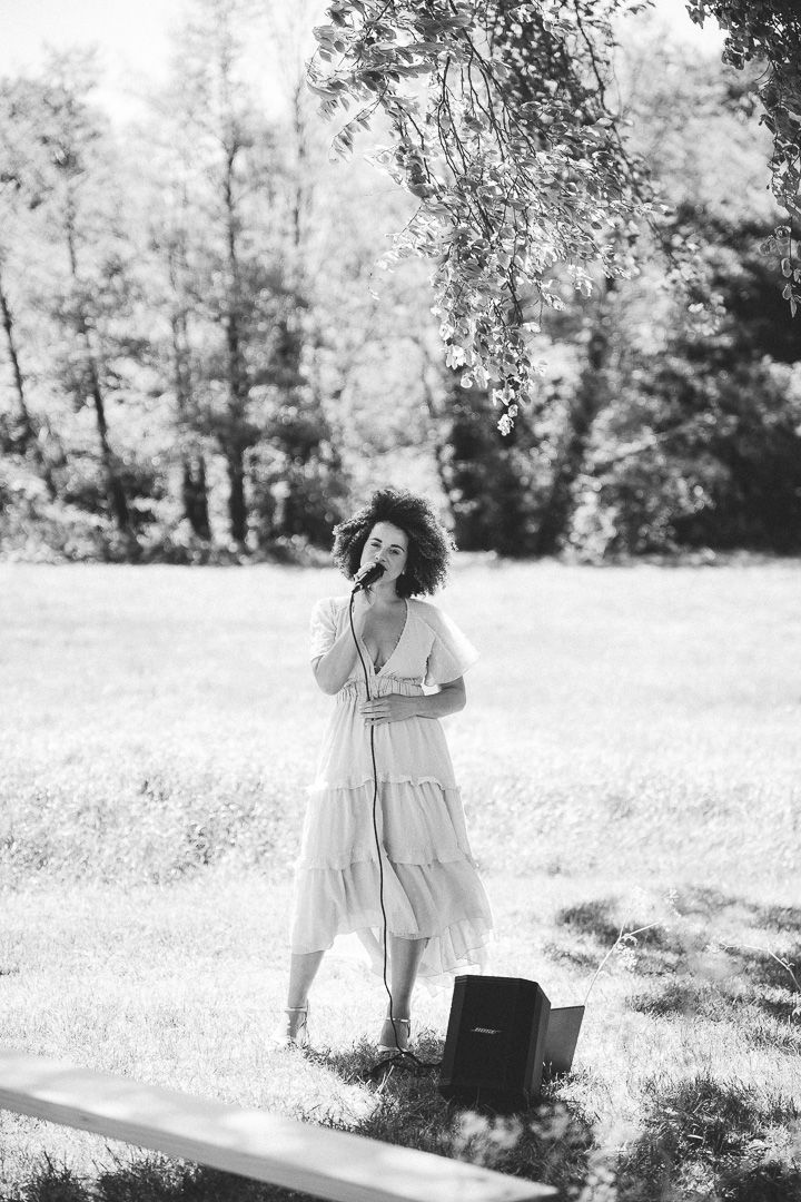 A dreamy series of black and white photos showing a woman in a flowy dress dancing in a sunlit meadow.