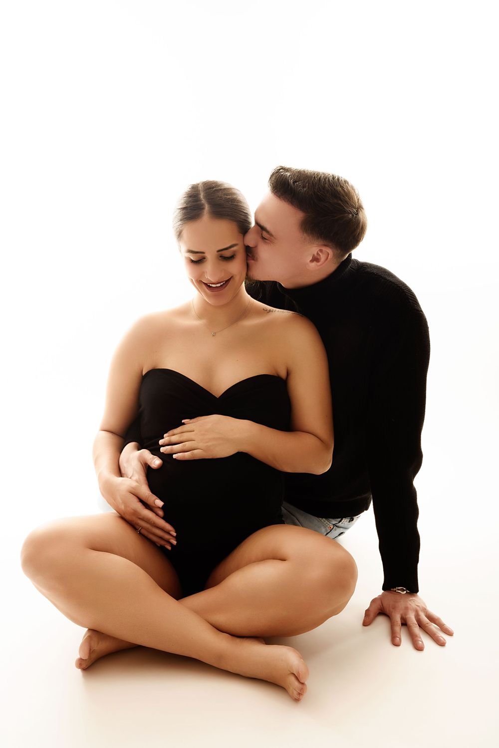 Intimate couple maternity photoshoot with black and white minimalist styling.