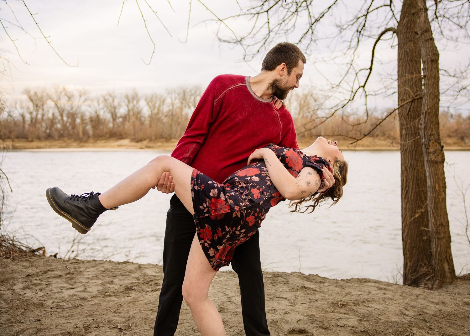 engaged couple taking engagement photos at a lake outside photoshoot