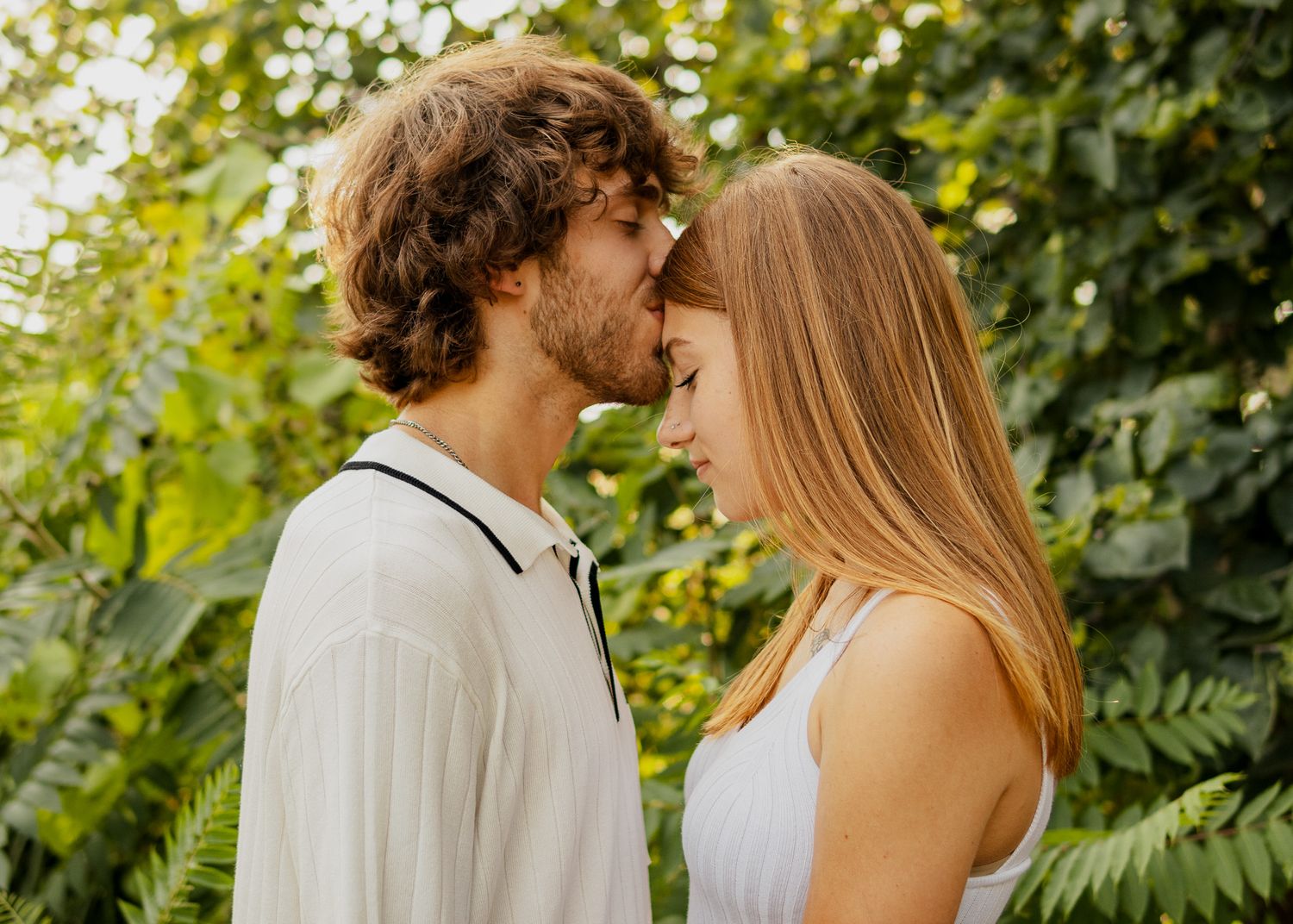 engaged couple taking engagement photos in a park outside