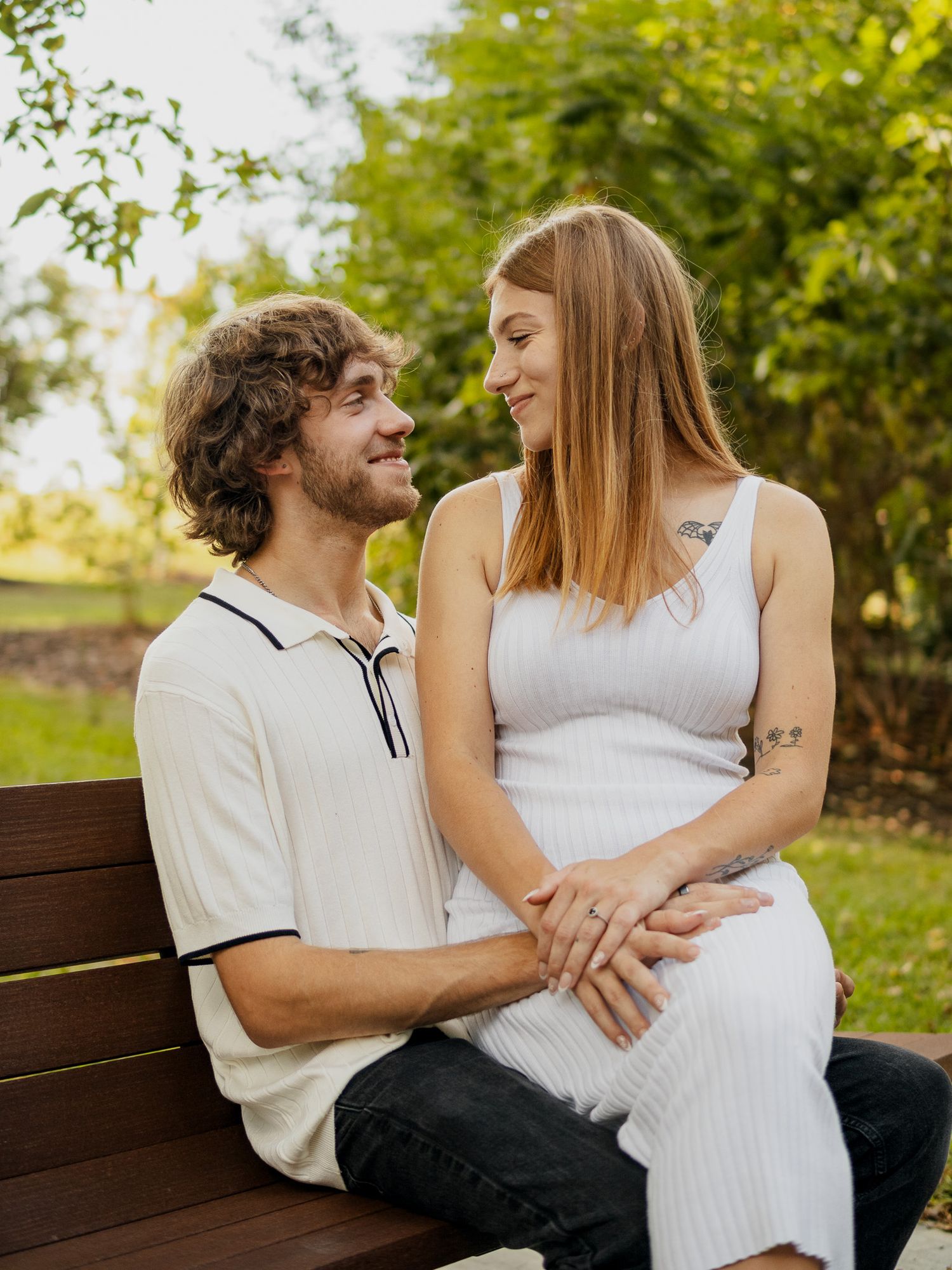 engaged couple taking engagement photos in a park outside