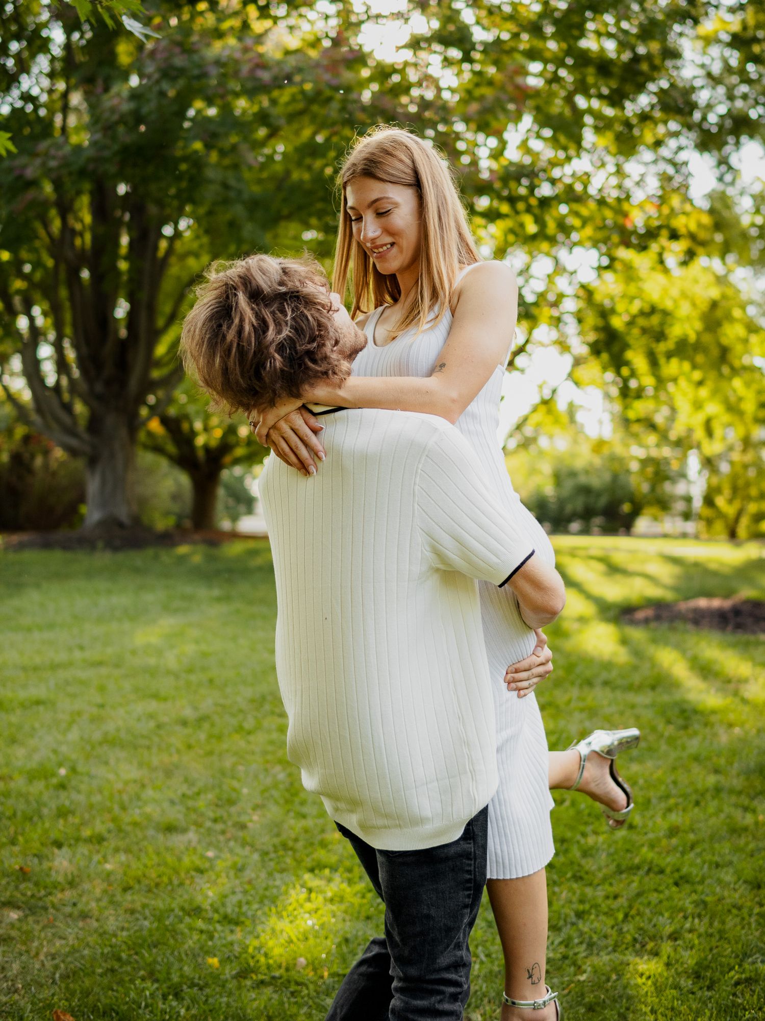 engaged couple taking engagement photos in a park outside