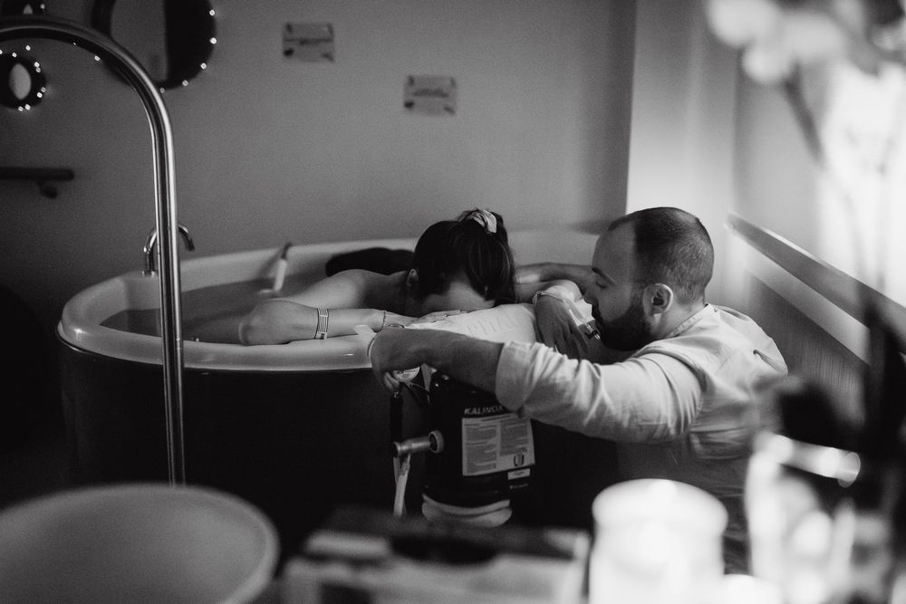 Moody black and white image showing massage therapy session in progress.