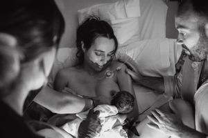 Medical professionals examining and caring for newborn baby in hospital setting.