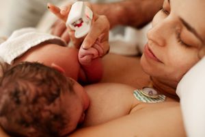 Intimate skin-to-skin bonding moment between parent and newborn baby in hospital.