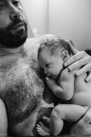 Black and white portrait of skin-to-skin bonding with newborn.