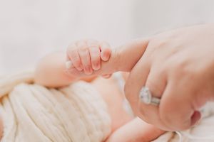 Close-up view of a sleeping newborn baby's tiny feet against a white background.